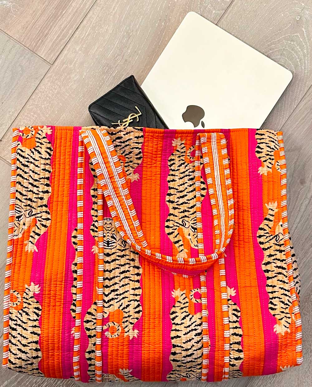 Colorful beach bag with tiger pattern on a wooden surface