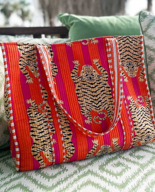Colorful beach bag with tiger pattern on a green and white surface